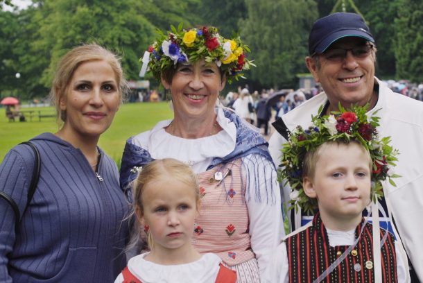 Grupp med fem personer, två av dem i midsommarkrans