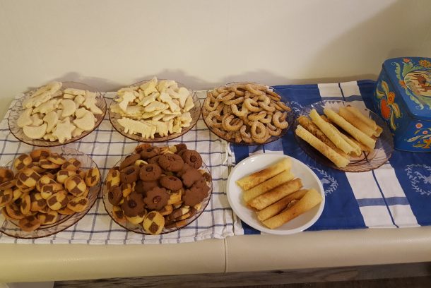 Sju sorters kakor på serveringsbord samt kakbruk i blått med häst på locket.