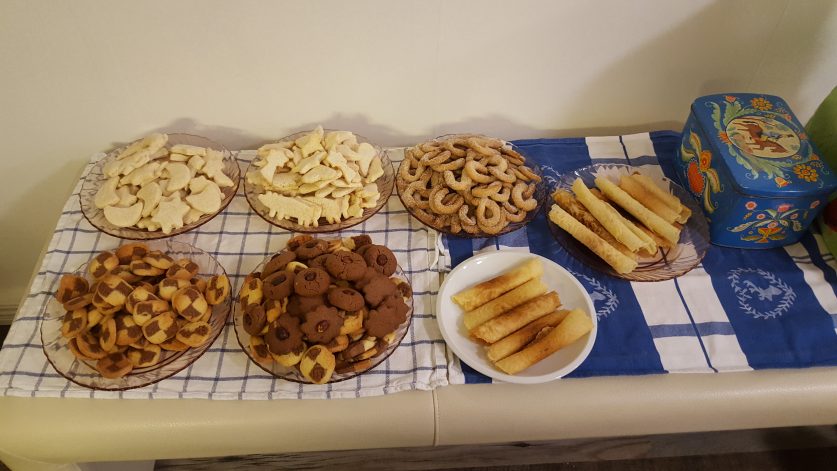 Sju sorters kakor på serveringsbord samt kakbruk i blått med häst på locket.