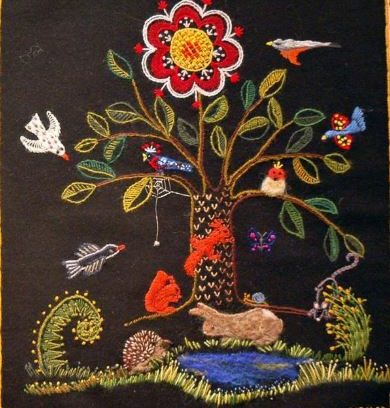 Broderat träd med ekorrar och fåglar i. Nedanför trädet en broderad damm med en kanin och en igelkott.