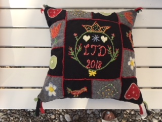 Kudde med hjärtan, blommor och fåglar. I mitten en inramad text "LTD 2018".