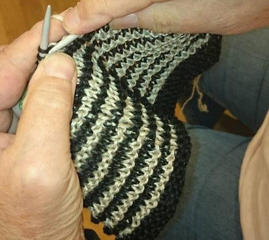 Händer med stickning