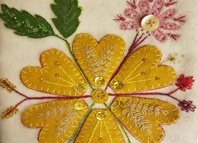 vackert broderad blomma i gult kläde