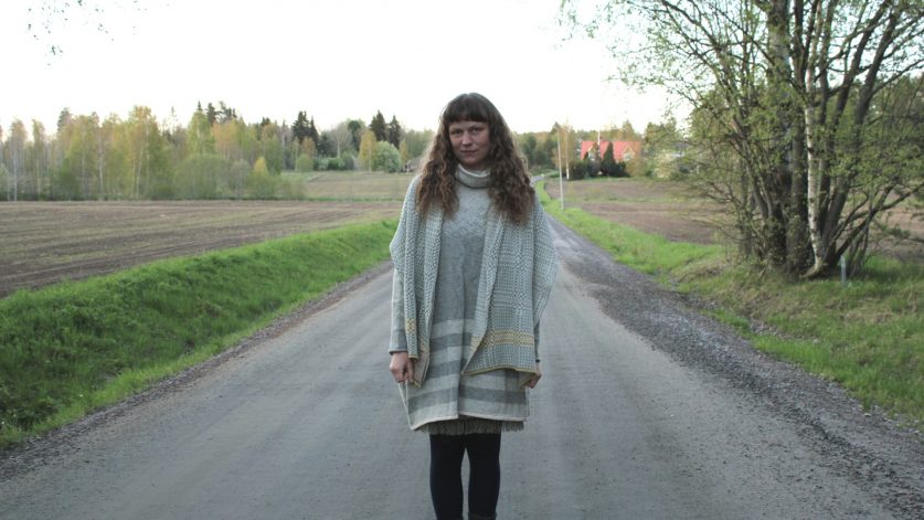 Bo Hammarskjöldstipendiaten Elmina Fors på grusväg iklädd stickat.
