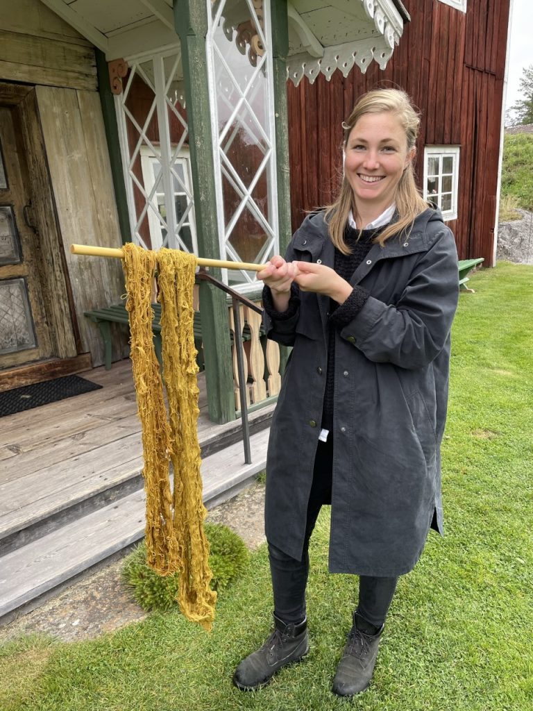 Samantha Gustafsson håller upp växtfärgat lin.