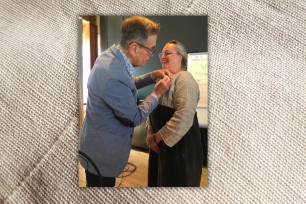 Håkan Liby i blå kavaj fäster silvermedalj på leende Marie Ekstedt Bjersings tröja.