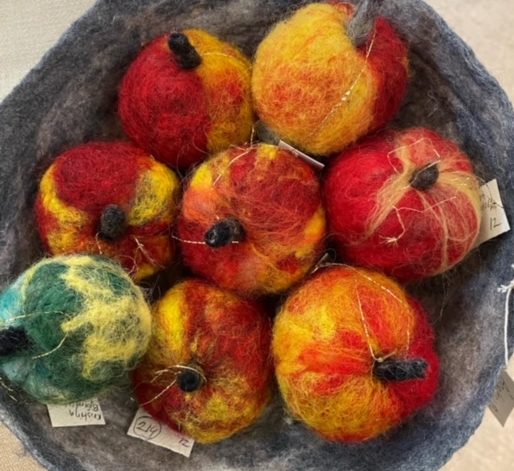 äpplen av nåltovad ull i en nåltovad skål